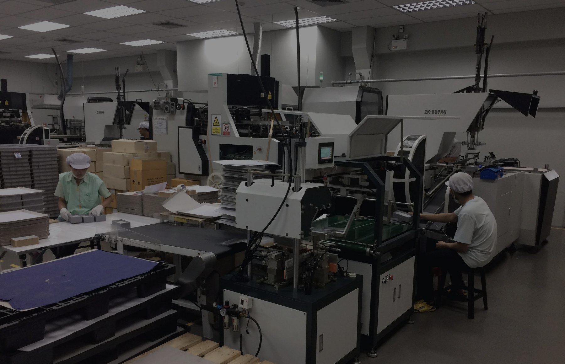 アジアの協力工場の生産ラインで作業するスタッフと機械設備