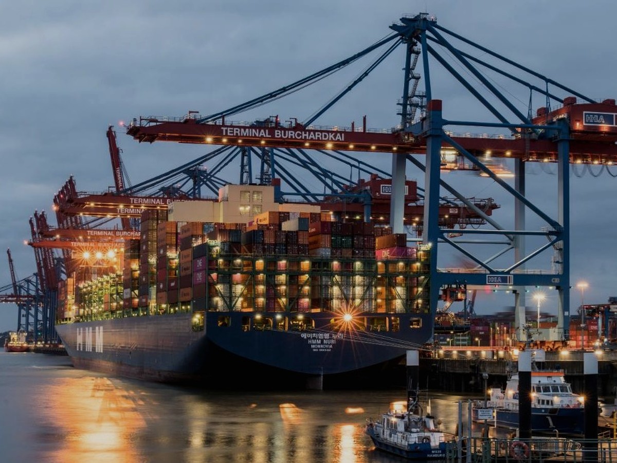 夜間のコンテナ港で稼働するガントリークレーン、出荷・納品体制